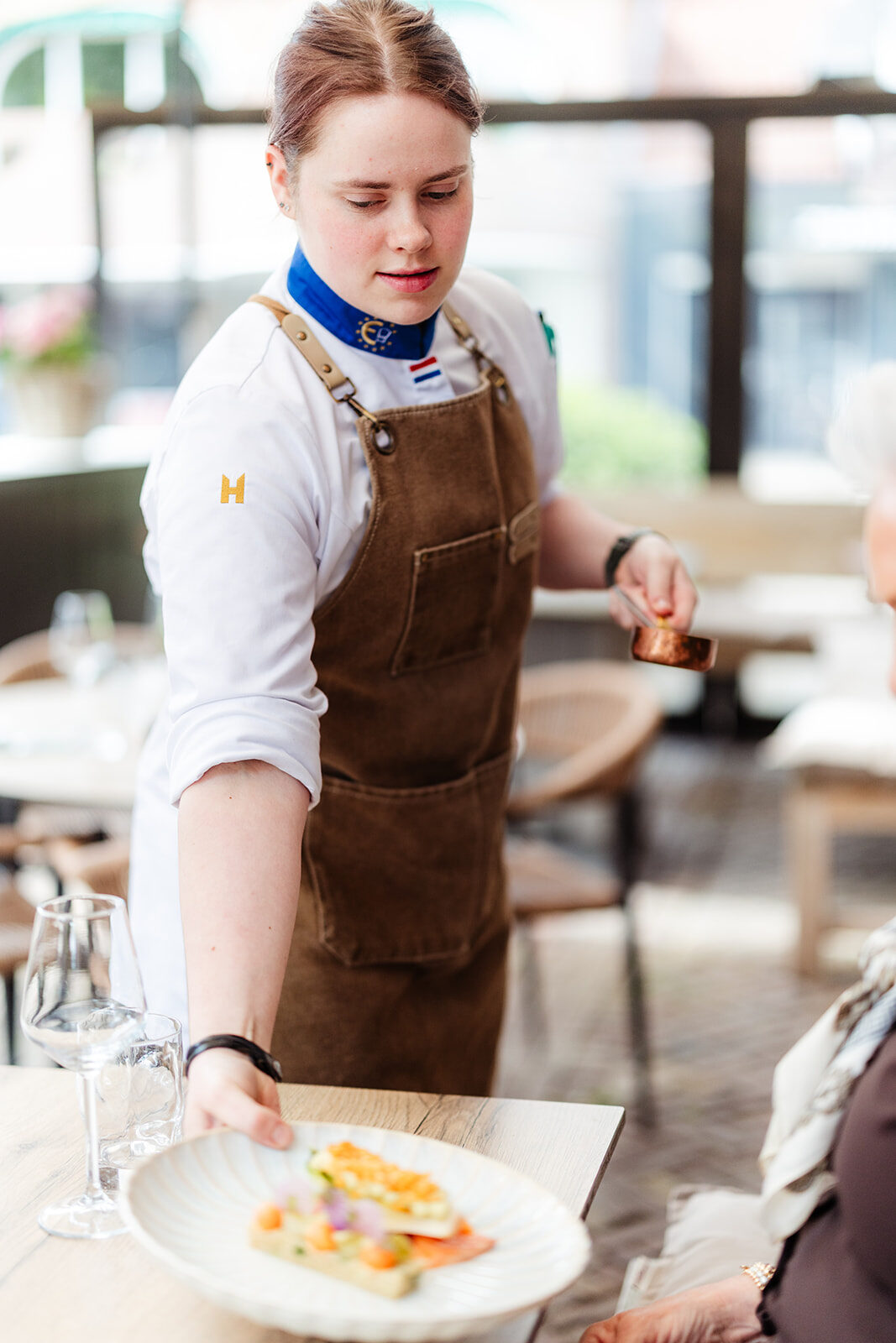 Bediening serveert een gerecht op het terras