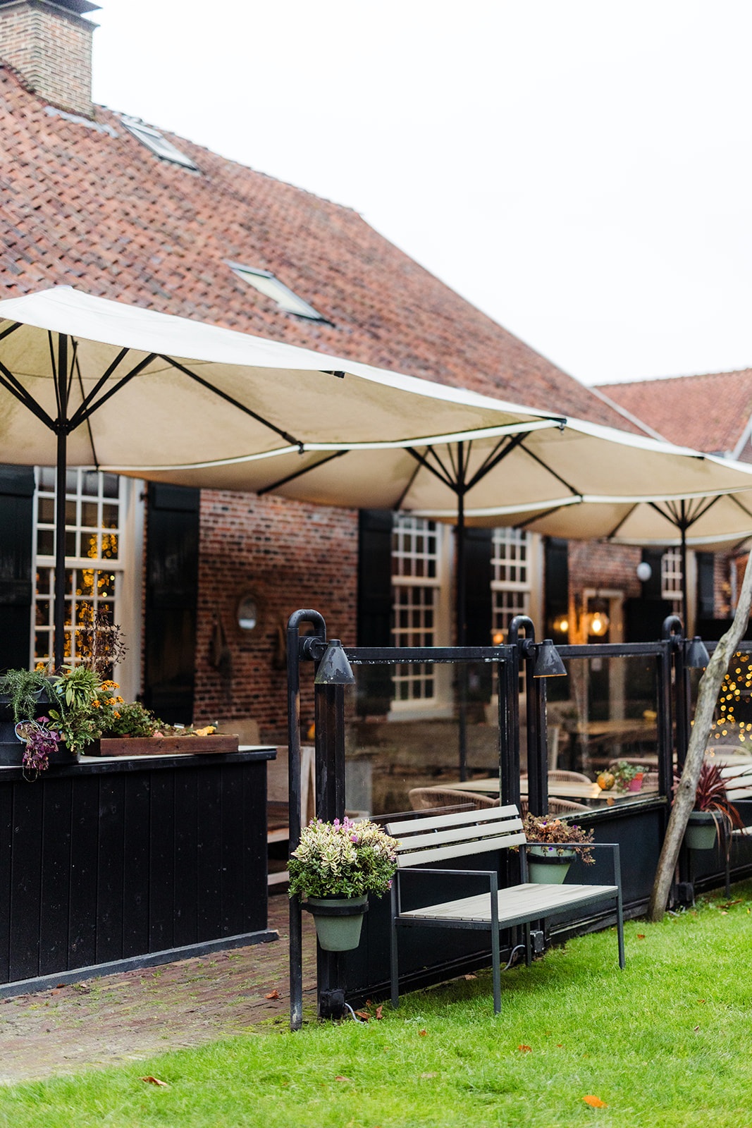 Tuinterras met parasols achter het historische pand