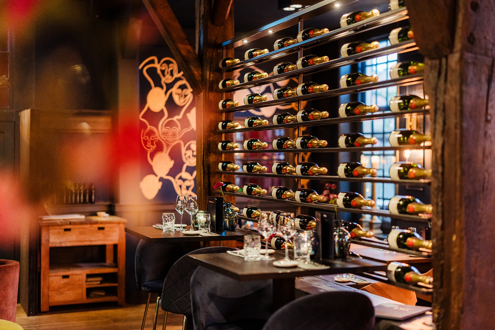 Wijnmuur en gedekte tafels in de eetzaal van Restaurant De Oude Apotheek