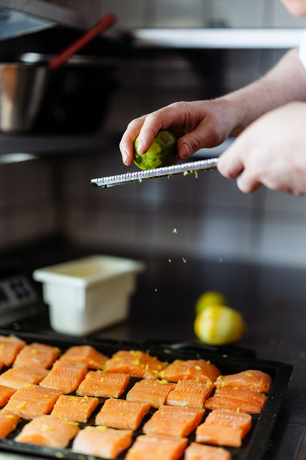Limoen wordt geraspt boven een bereiding in de keuken