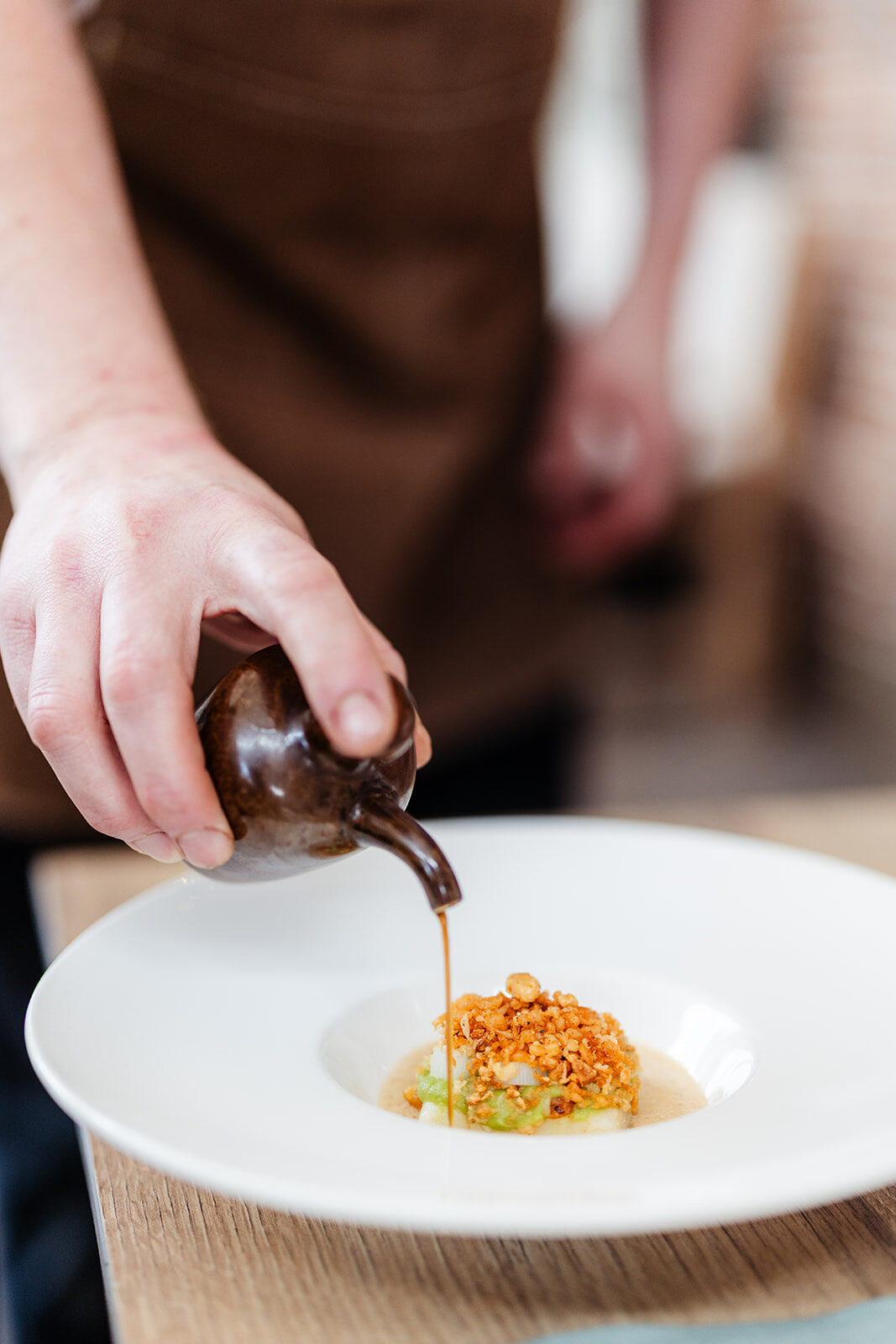 Saus wordt over een gerecht geschonken